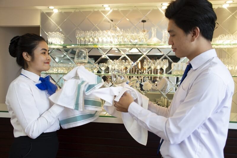 Nhân viên chạy bàn lau dọn ly